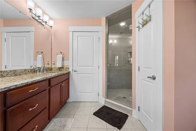 a bathroom with a granite countertop sink a mirror and shower