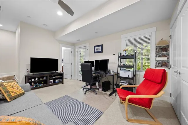a living room with furniture a flat screen tv and a large window