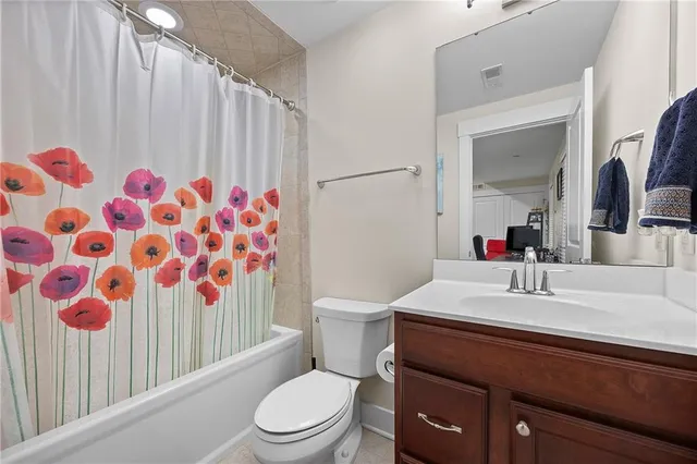 a bathroom with a sink a toilet and shower curtain