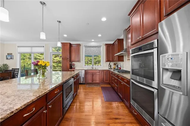 a large kitchen with granite countertop lots of counter space and stainless steel appliances