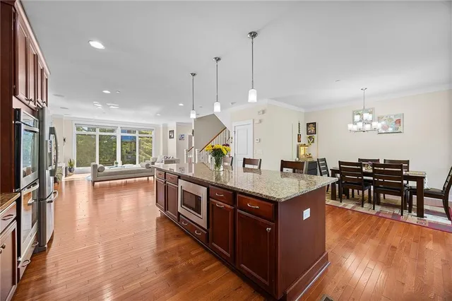 a open kitchen with stainless steel appliances granite countertop a stove and a view of living room