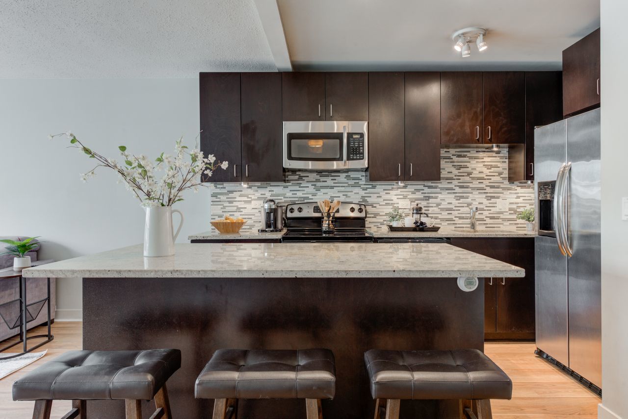 2930 North Sheridan Road, Unit 1010 Chicago, IL 60657 - Photo 11 of 24 a kitchen with cabinets and chairs