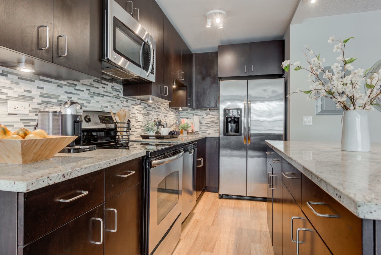 2930 North Sheridan Road, Unit 1010 Chicago, IL 60657 - Photo 12 of 24 a kitchen with stainless steel appliances granite countertop a sink a stove and a wooden floors