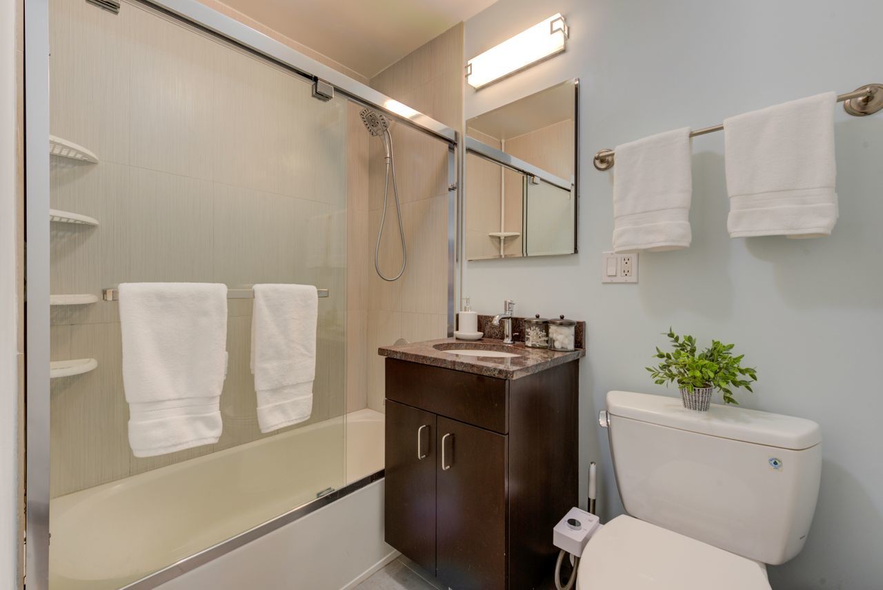 2930 North Sheridan Road, Unit 1010 Chicago, IL 60657 - Photo 14 of 24 a bathroom with a granite countertop toilet sink and mirror