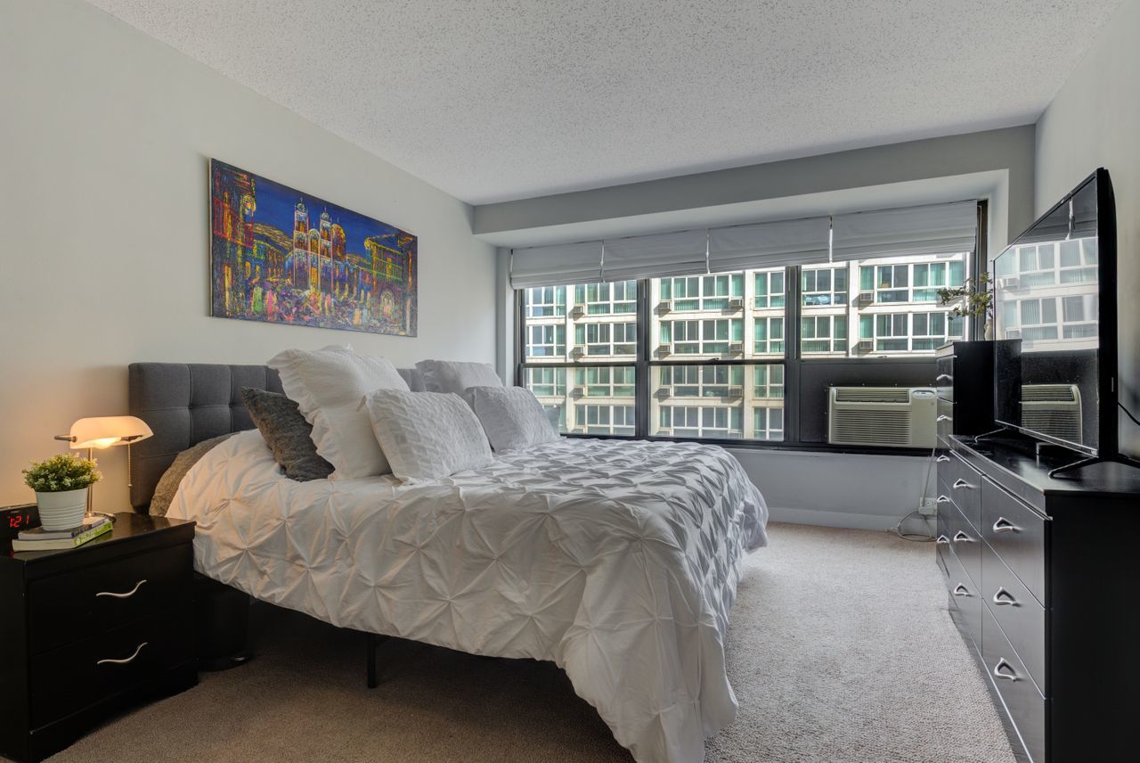 2930 North Sheridan Road, Unit 1010 Chicago, IL 60657 - Photo 15 of 24 a bed sitting in a bedroom next to a window