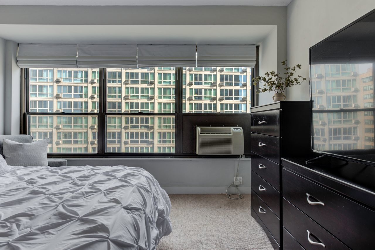 2930 North Sheridan Road, Unit 1010 Chicago, IL 60657 - Photo 16 of 24 a bedroom with a bed and wooden floor