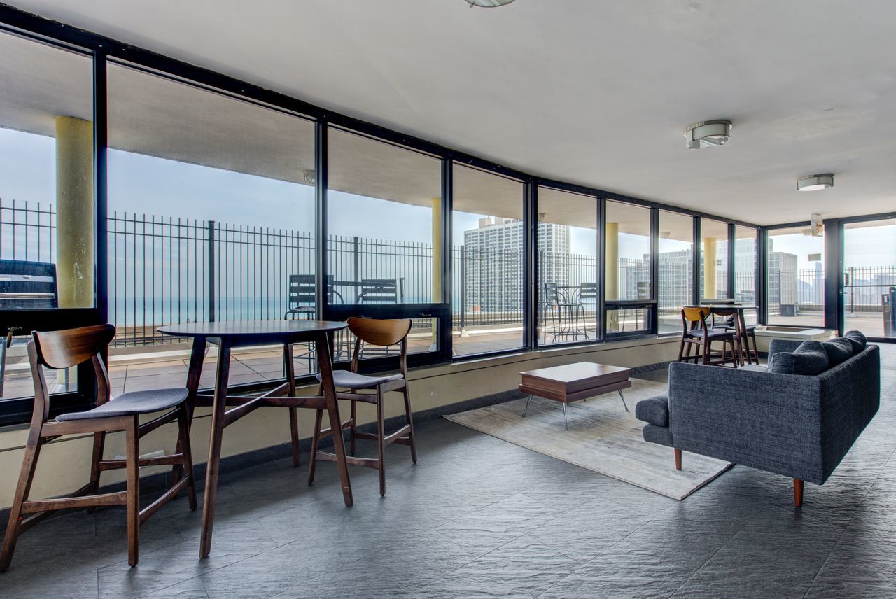 2930 North Sheridan Road, Unit 1010 Chicago, IL 60657 - Photo 18 of 24 a living room with furniture and a floor to ceiling window