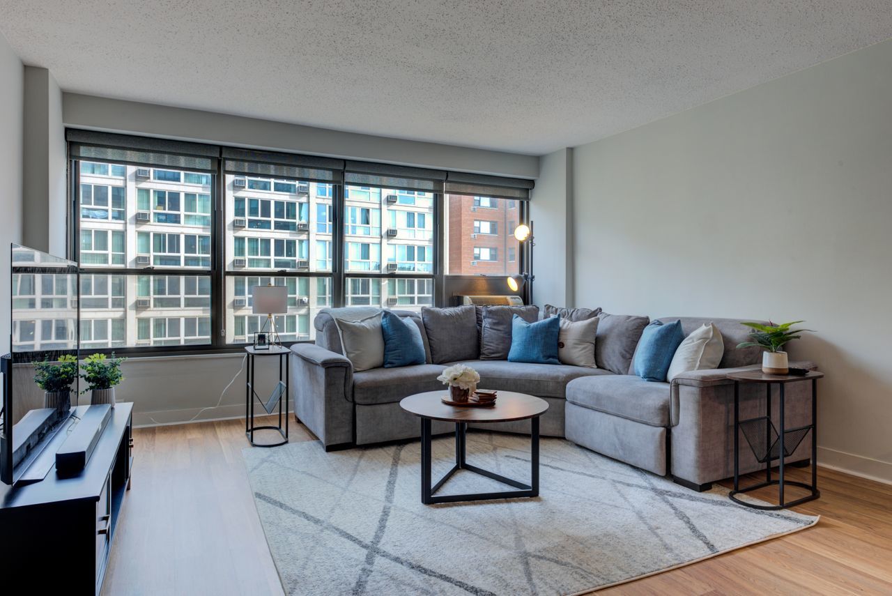 2930 North Sheridan Road, Unit 1010 Chicago, IL 60657 - Photo 6 of 24 a living room with furniture and a floor to ceiling window
