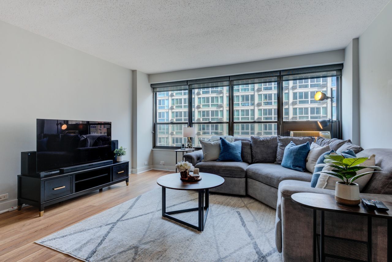 2930 North Sheridan Road, Unit 1010 Chicago, IL 60657 - Photo 7 of 24 a living room with furniture a flat screen tv and a large window
