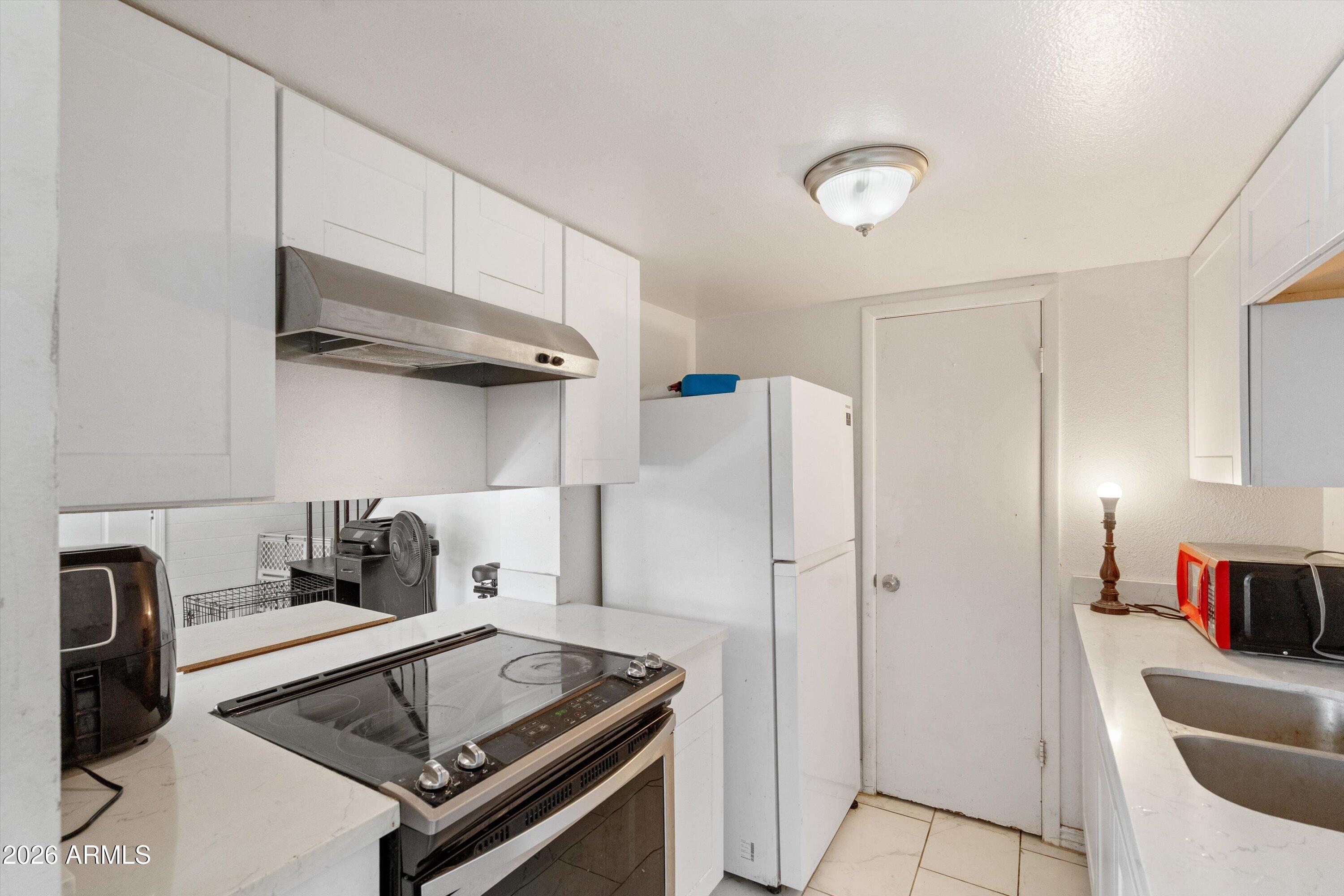 600 South Dobson Road, Unit 88 Mesa, AZ 85202 - Photo 13 of 18 a kitchen with stainless steel appliances granite countertop a refrigerator and a stove