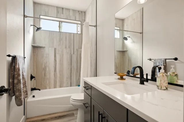 a bathroom with a sink a toilet and a mirror