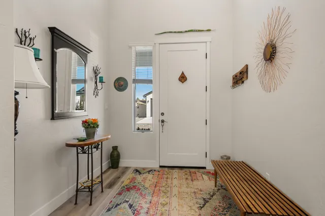a view of a hallway with entryway and wooden floor