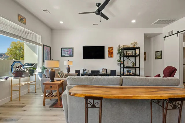 a living room with stainless steel appliances kitchen island granite countertop furniture and a flat screen tv