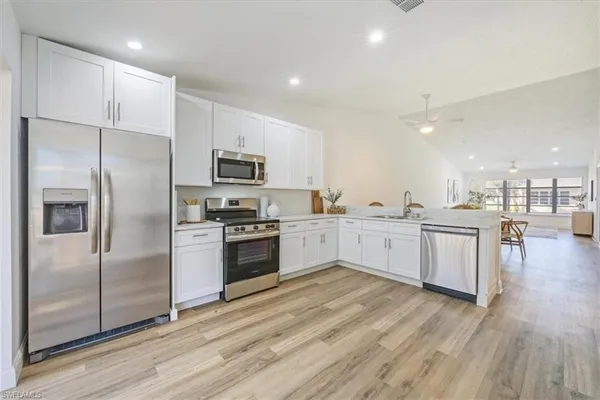 a large kitchen with a refrigerator a sink and a stove top oven