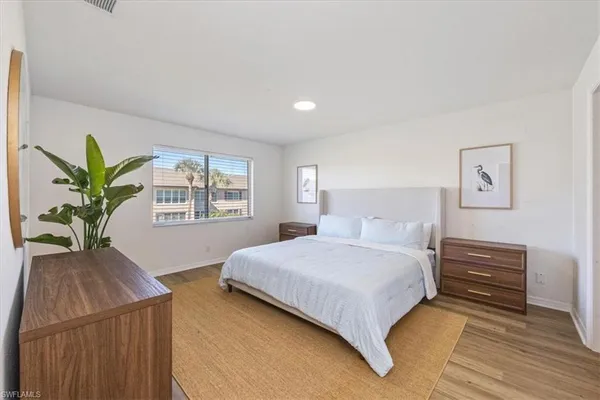 a bedroom with a large bed and a potted plant