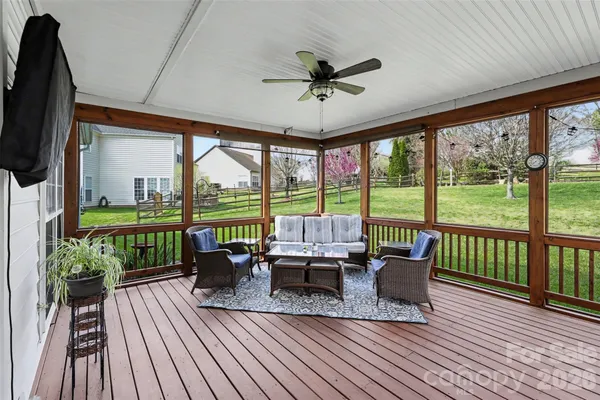 a living room with furniture a flat screen tv and a floor to ceiling window