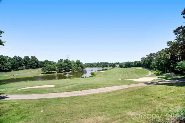 a view of swimming pool with outdoor seating and trees in the background