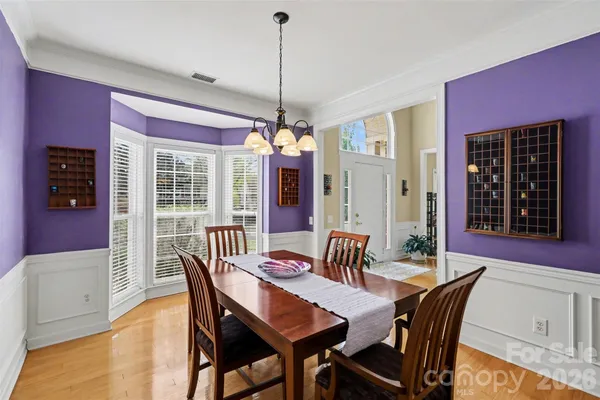 a kitchen with stainless steel appliances granite countertop a stove a refrigerator a kitchen island a table and chairs