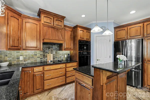 a kitchen with stainless steel appliances granite countertop a sink and a stove