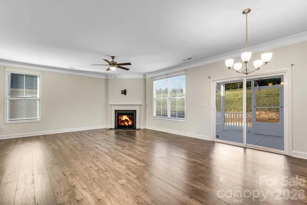 a view of a livingroom with wooden floor a fireplace and windows