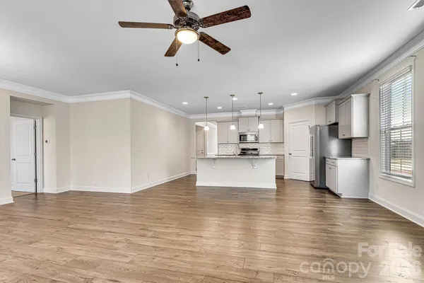 a view of kitchen with kitchen island wooden cabinets and refrigerator