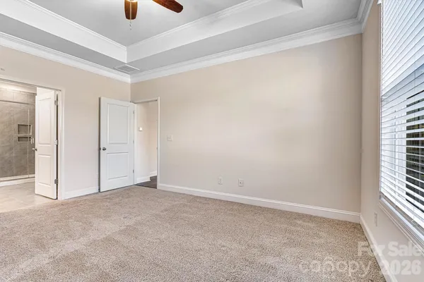 an empty room with windows and fan