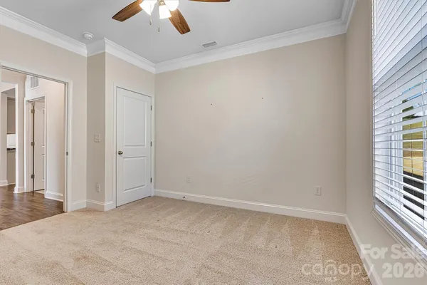 an empty room with a ceiling fan and windows