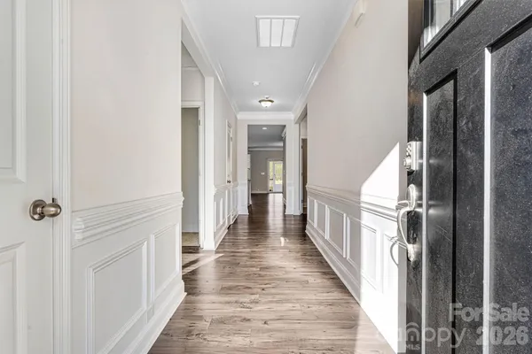 a view of a hallway with wooden floor and staircase