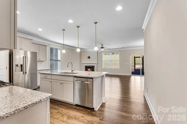 a kitchen with stainless steel appliances granite countertop a sink a stove and a refrigerator