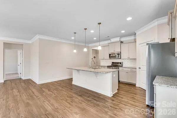 a kitchen with kitchen island a sink stainless steel appliances and white cabinets