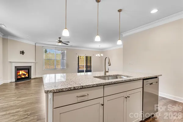a kitchen with granite countertop a sink and a chandelier