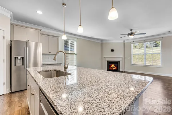 a kitchen with stainless steel appliances granite countertop a sink a refrigerator and a stove