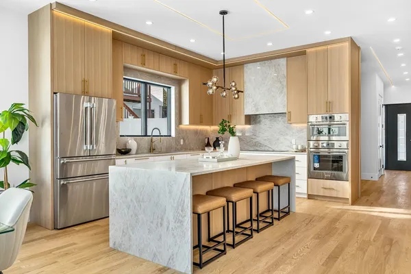 a kitchen with kitchen island a large counter top space a sink stainless steel appliances and cabinets