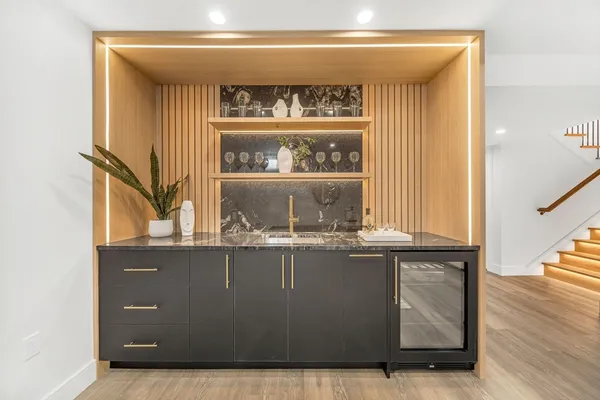 a large white kitchen with lots of counter space and chandelier