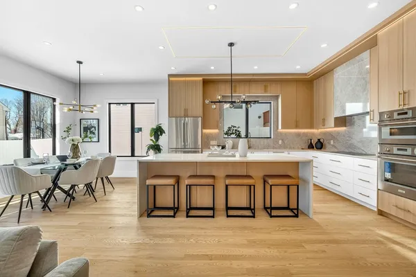 a kitchen with kitchen island granite countertop a sink a counter top space stainless steel appliances and cabinets
