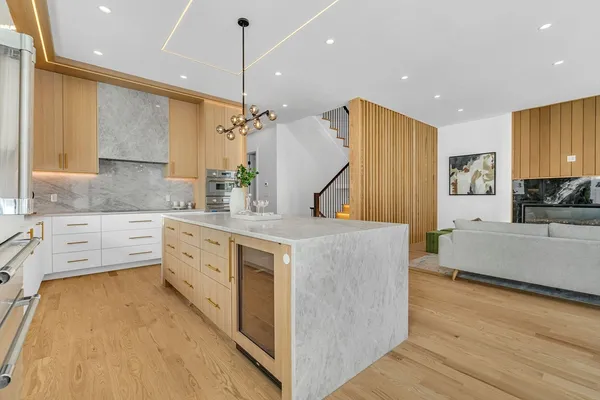 a large kitchen with kitchen island a large counter top space and stainless steel appliances