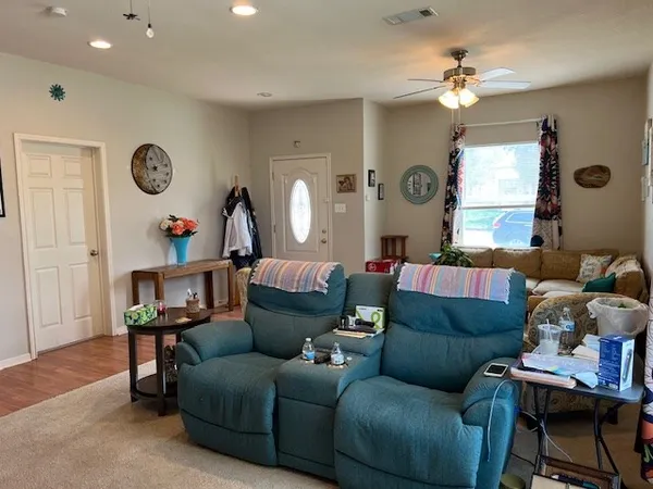 a living room with furniture a ceiling fan and a window