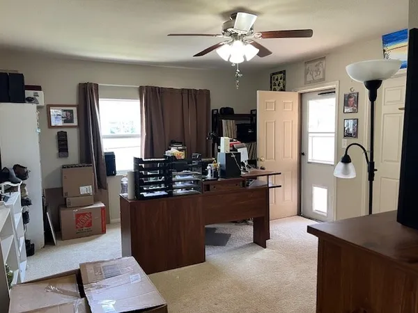 a kitchen with stainless steel appliances kitchen island granite countertop a refrigerator a sink dishwasher a dining table and chairs with wooden floor