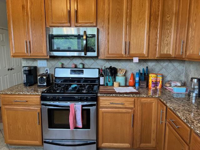 406 West 8th Street Brady, TX 76825 - Photo 10 of 33 a kitchen with stainless steel appliances granite countertop a stove a sink and a microwave