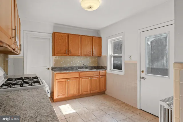 a kitchen with granite countertop stainless steel appliances white cabinets granite counter tops and a hard wood floors