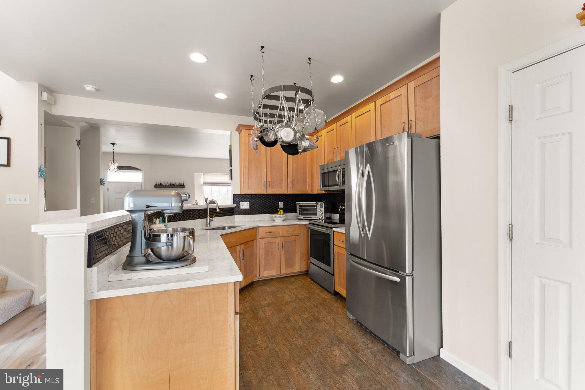 6377 St Timothys Lane Centreville, VA 20121 - Photo 19 of 58 a kitchen with refrigerator a sink and cabinets