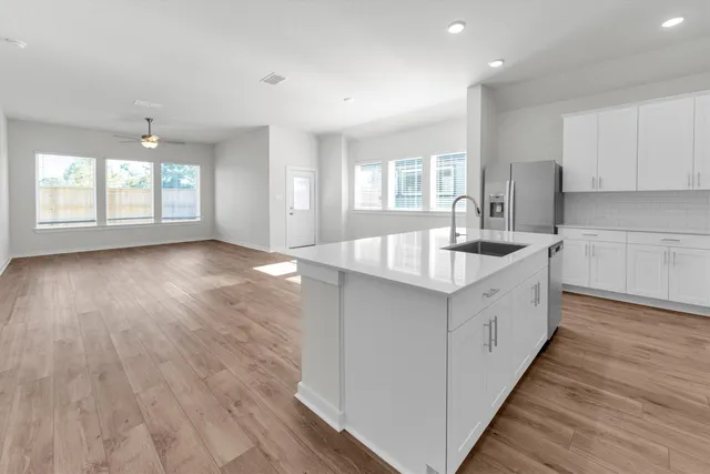 a kitchen with stainless steel appliances a sink a stove a microwave a center island and cabinets