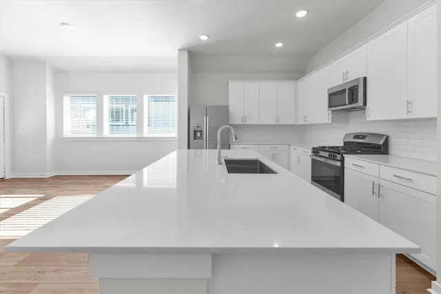 a room with a sink cabinets and wooden floor