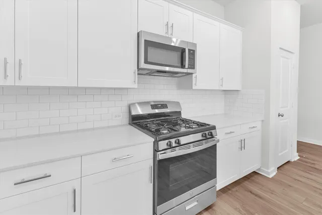 a kitchen with sink stove and cabinets