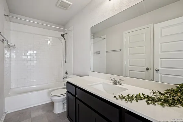 a bathroom with a granite countertop sink a toilet and shower
