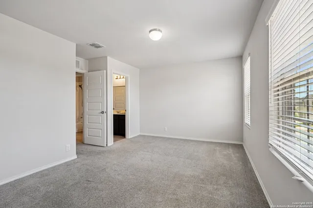 an empty room with windows and closet