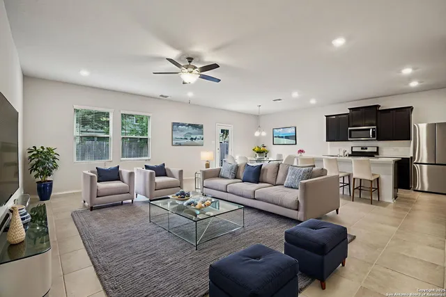a living room with furniture flat screen tv and windows