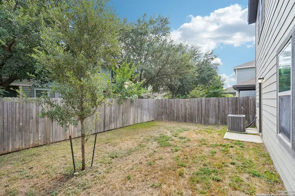 a view of a backyard with wooden fence