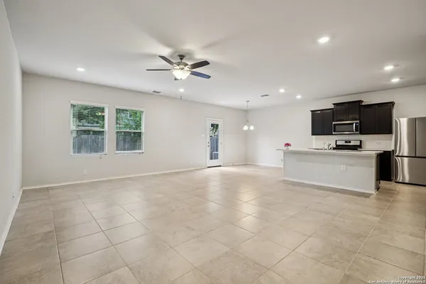 a view of kitchen with stainless steel appliances kitchen island granite countertop a stove top oven a sink a refrigerator with grey cabinets and glass door