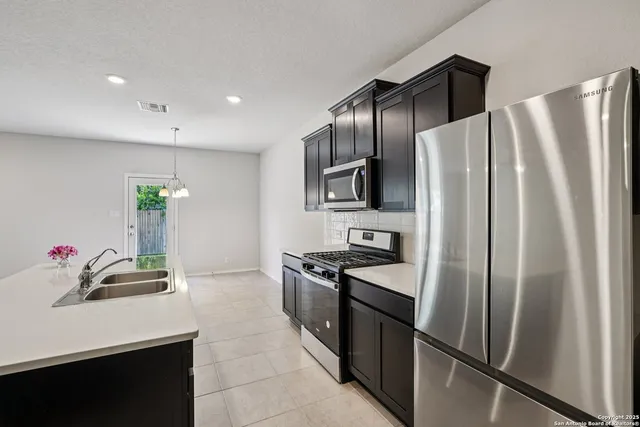 a kitchen with stainless steel appliances a refrigerator sink and microwave